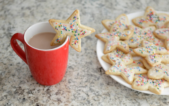 Receta de polvorones con grageas por Camille Conde Montero. Polvorones en forma de estrellas de Navidad con un corte para poner en la taza roja de café caliente