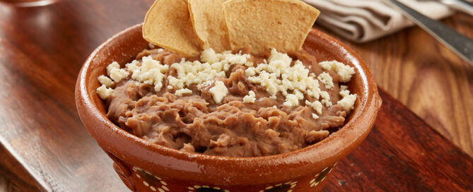 Refrito de habichuelas con sofrito seco, orégano y comino Montero, suave, calientito y genial para acompañar cada chip.