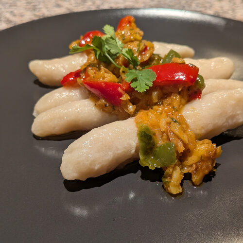 Este bacalao guisado es perfecto para servir con guanimos, ya que su salsa rica y aromática complementa la textura suave y neutra de estos. El resultado es un plato tradicional, profundo en sabor y con un perfil caribeño auténtico.